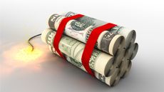 Several rolls of cash are strapped together like sticks of dynamite and have a lighted fuse.