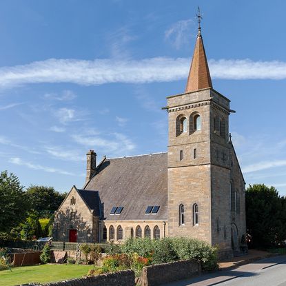 church house with gothic arched windows and stone walls