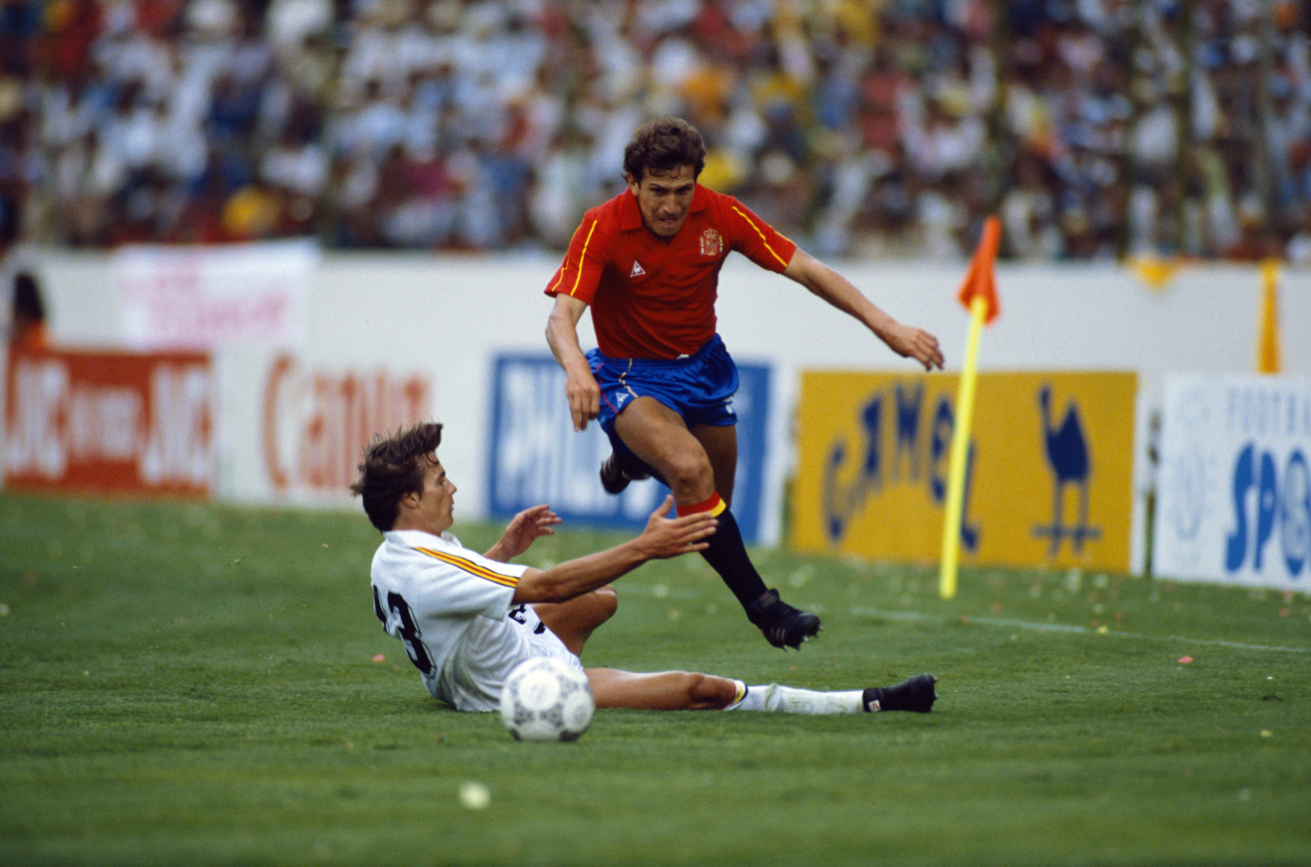 Victor Muñoz of Spain jumps over a Belgium defender in the teams' 1986 World Cup quarter-final.