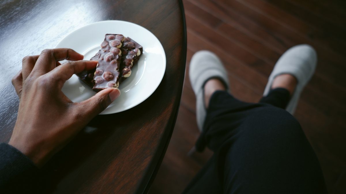 Hand picks up piece of chocolate from a plate