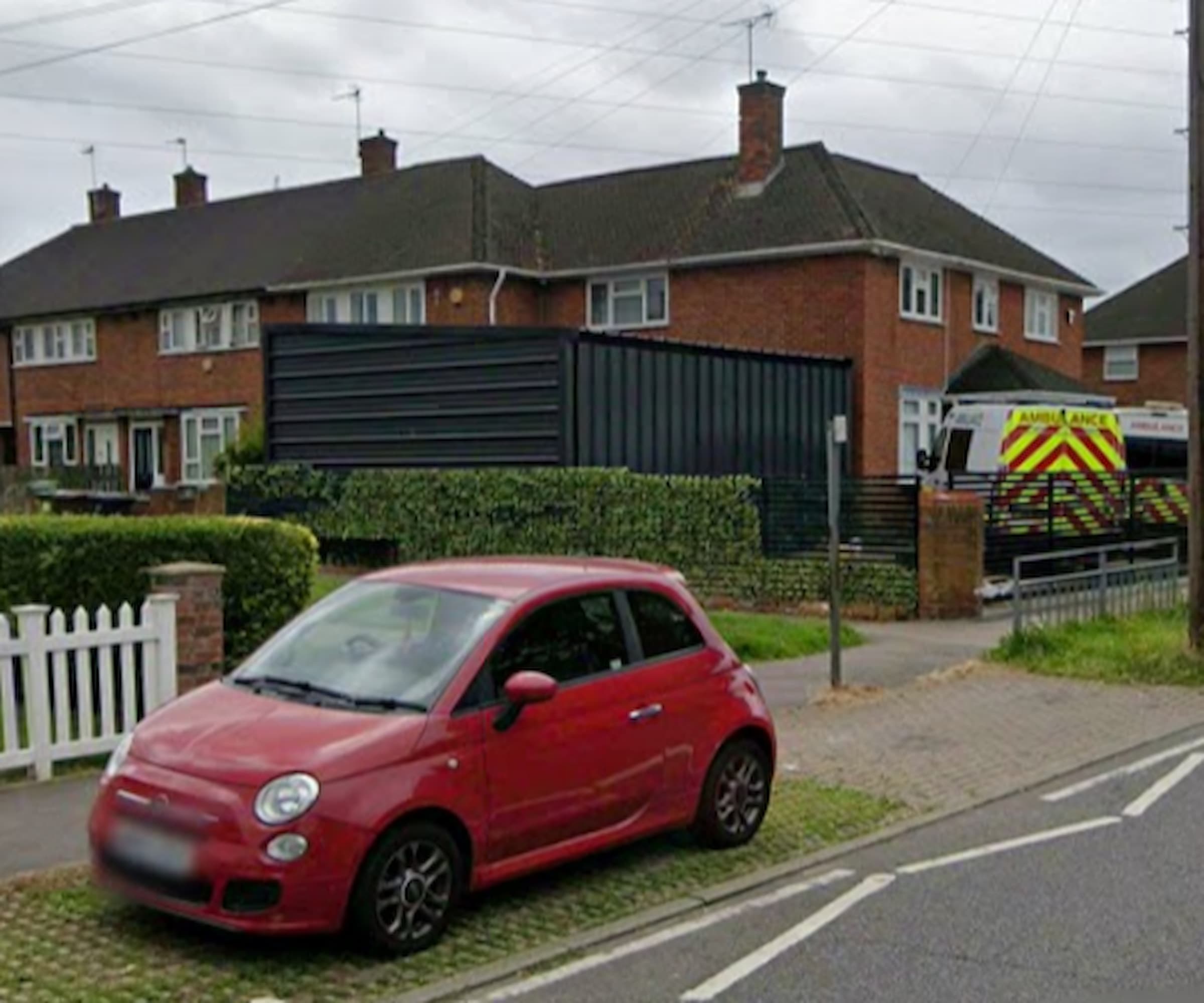 A large dark green garage as seen from the road