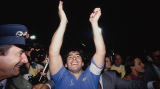 STUTTGART, GERMANY - MAY 17: Napoli captain Diego Maradona surrounded by media and police celebrates after the 1989 UEFA Cup Final second leg between VFB Stuttgart and S.S.C Napoli at Neckarstadion on May 17, 1989 in Stuttgart, West Germany. (Photo by Simon Bruty/Allsport/Hulton Archive/Getty Images)
