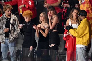 Taylor Swift in the stands at the Super bowl with dark eye makeup and red lipstick