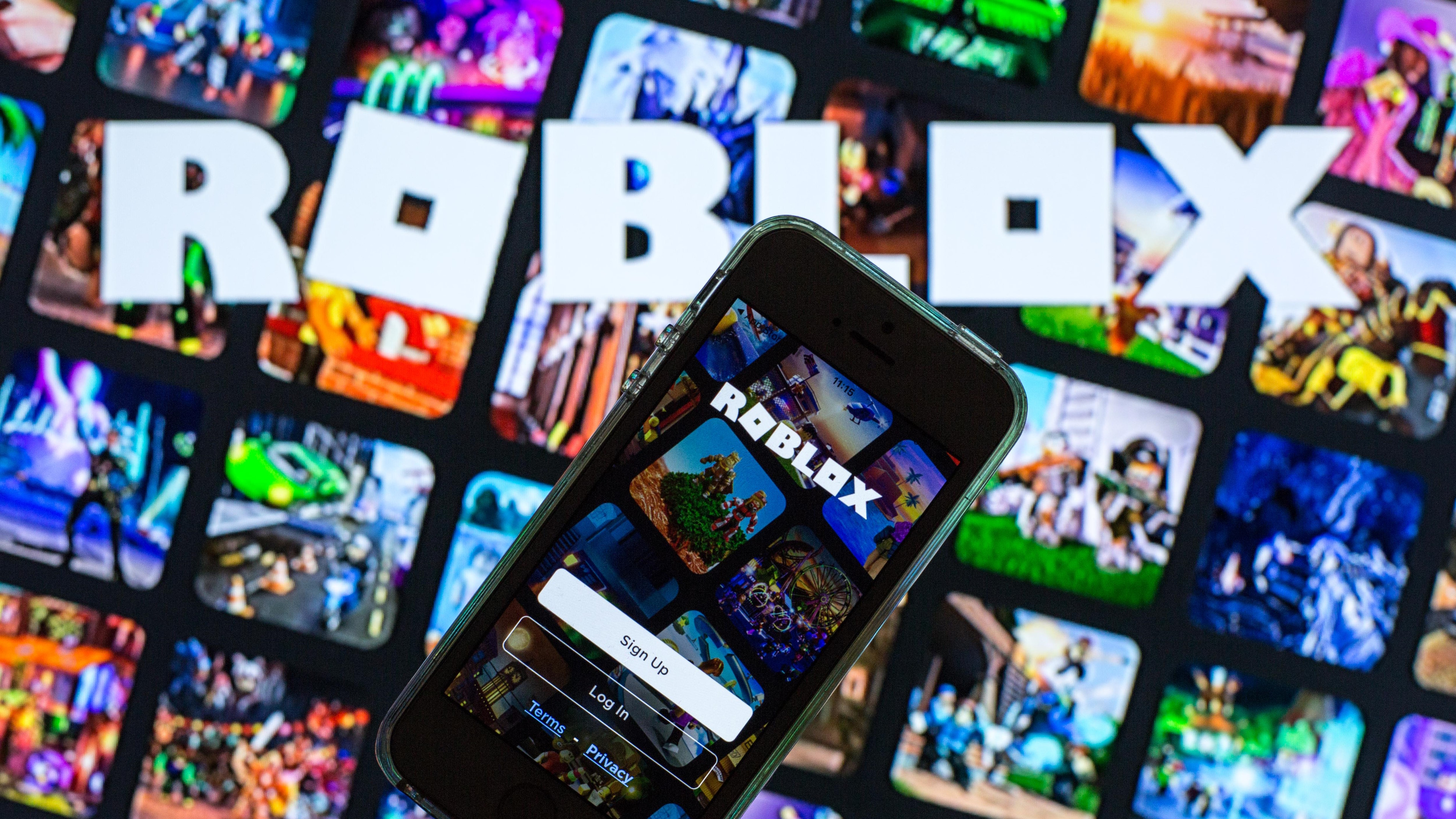 SPAIN - 2021/03/30: In this photo illustration, the Roblox app seen displayed on a smartphone screen and a Roblox logo in the background. (Photo Illustration by Thiago Prudêncio/SOPA Images/LightRocket via Getty Images)