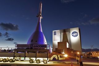 A prototype NASA Orion space capsule, equipped with its emergency abort motors passes by the agency's massive Vehicle Assembly Building at the Kennedy Space Center in Cape Canaveral, Florida on May 22, 2019. NASA will launch the capsule on Ascent Abort 2 (AA-2), a flight test to check Orion's abort system, on July 2.