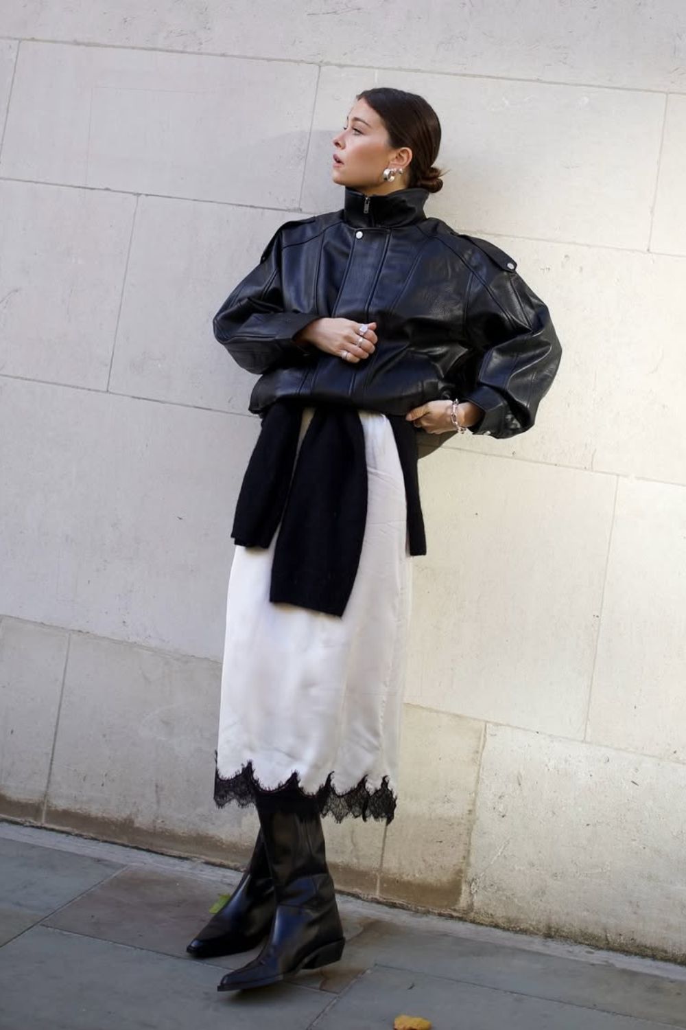 @thealiceedit Black Boot Outfits wearing a leather jacket, cream lace slip skirt and black western cowboy boots