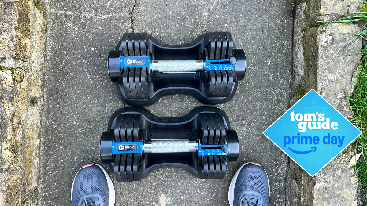 LifePro PowerFlow Plus adjustable dumbbells next to someone's feet on a garden path
