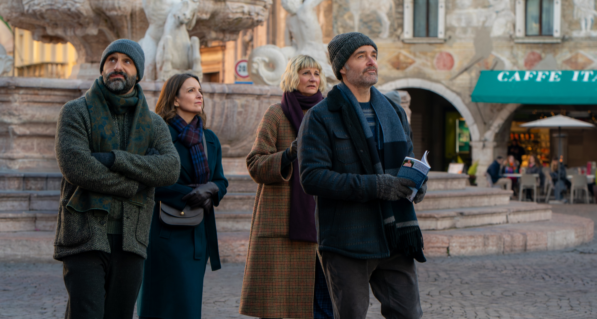 a group of friends walk through an italian square in a still from the four seasons season 2