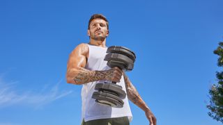 Luke Zocchi holding an adjustable dumbbell