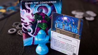 Marvel Villainous: Twisted Ambitions Kang the Conqueror villain guide, mover, cards, and tokens on a wooden table