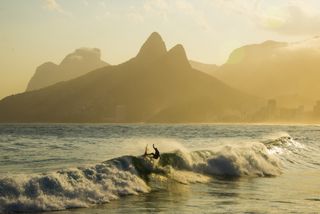 Surfers ride waves off of Ipanema Beach in Rio de Janeiro, Brazil