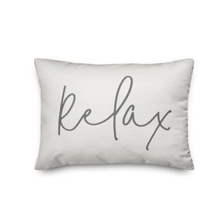 A white throw pillow that says "relax"
