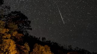 a meteor streaks through a starry sky