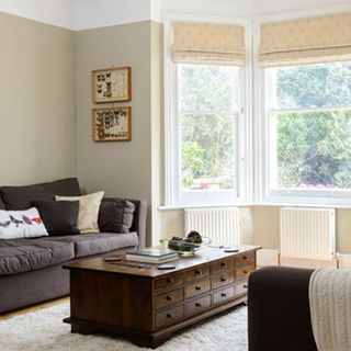 living room with cream wall and brown sofa set with cushions