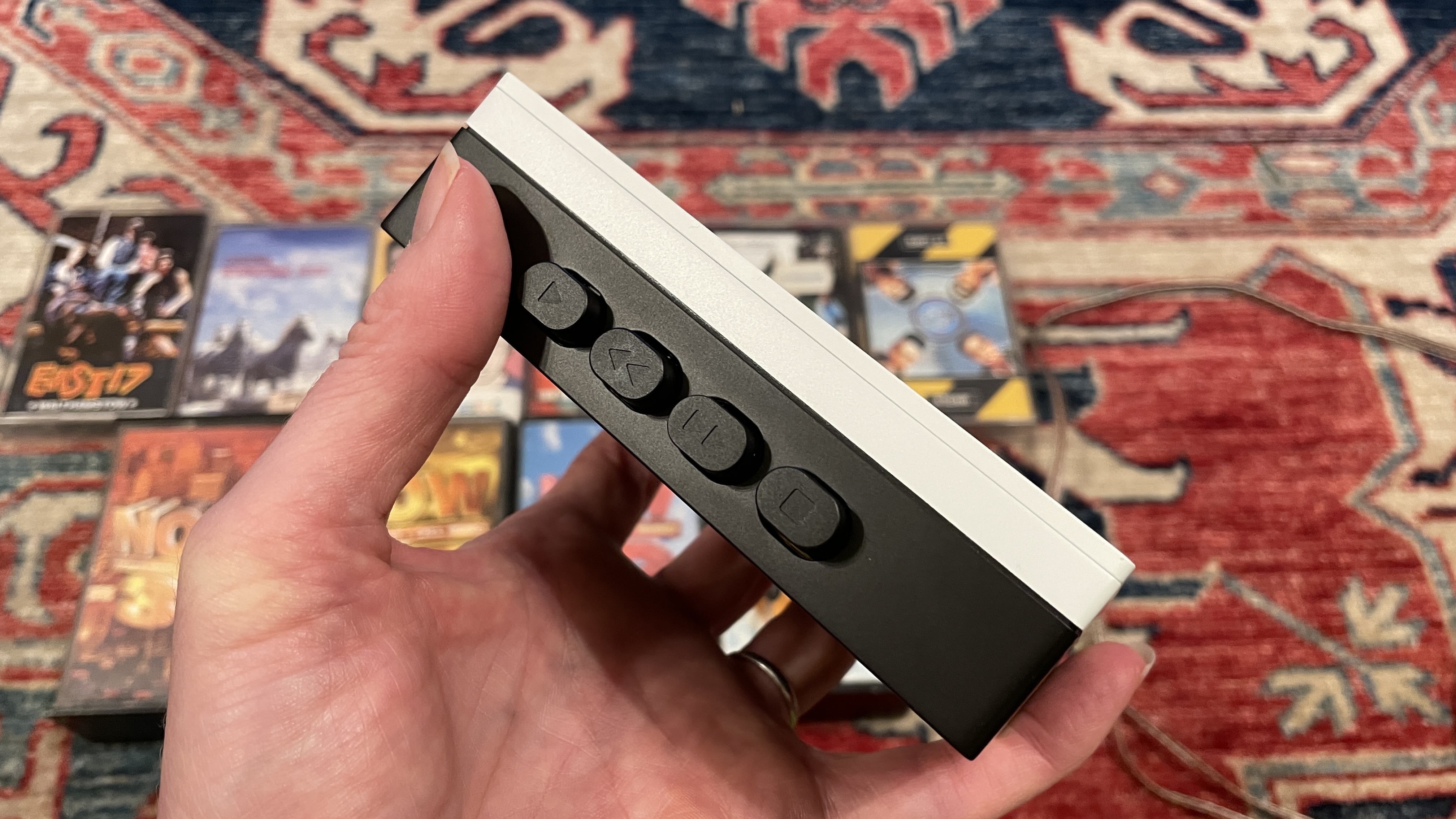 FiiO's CP13 with Campfire Audio Clara IEMs, on top of several cassette tapes, all on a colorful carpet