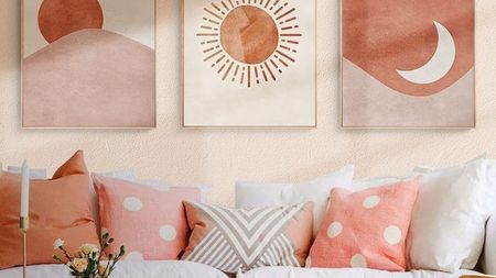 Sunny, boho lounge with wall art and throw pillows in soft terracotta shades