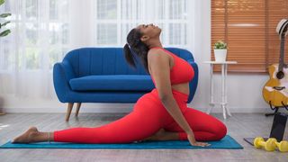 Woman in red yoga wear doing yoga in her living room