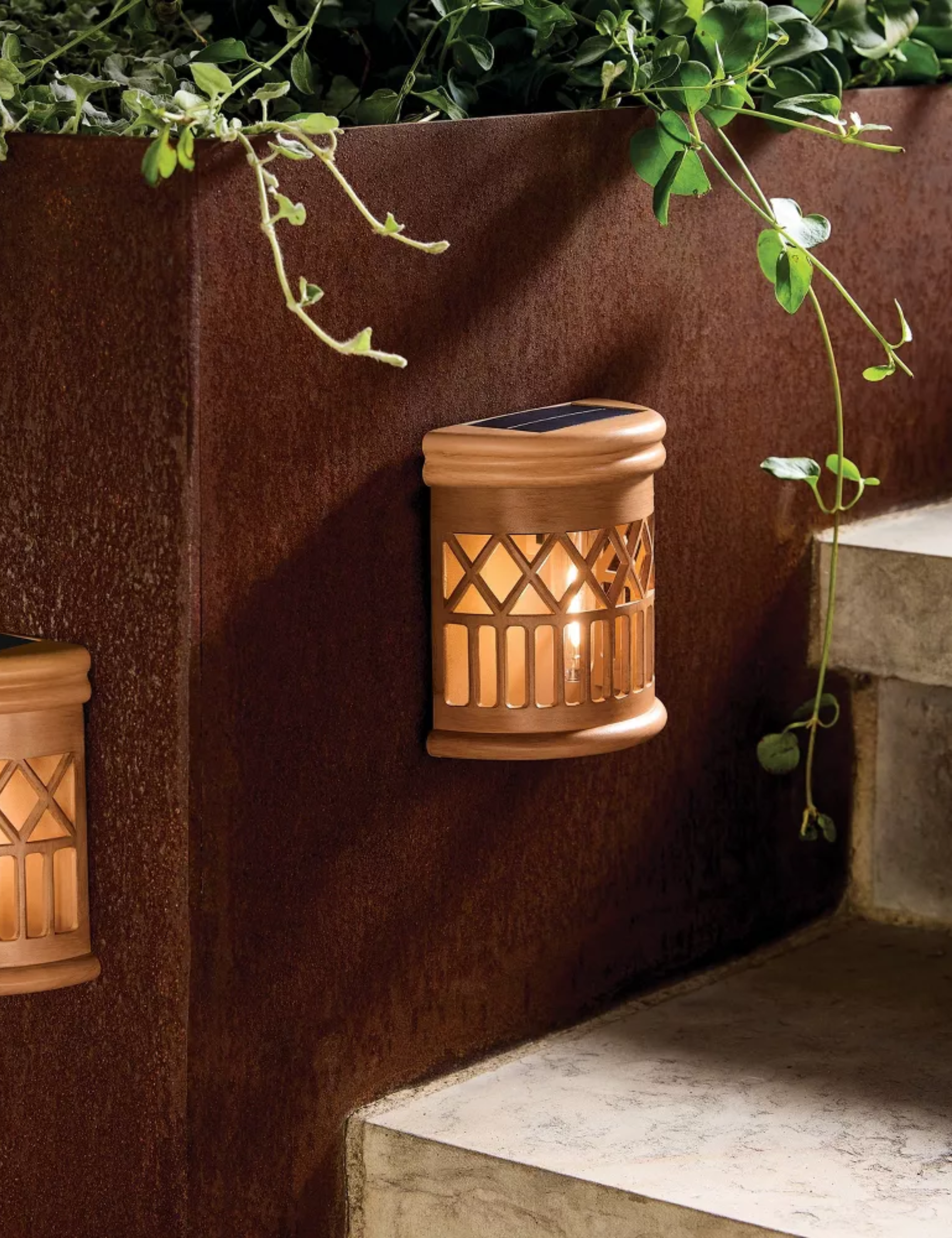 Woven solar outdoor fence lamps affixed to a terracotta patio wall