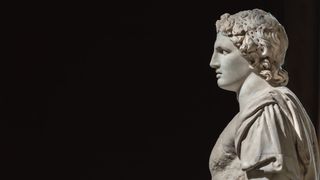 A marble bust of Alexander the Great against a black background.