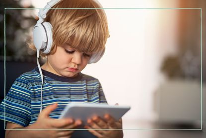 A toddler watching a video on a tablet with headphones on