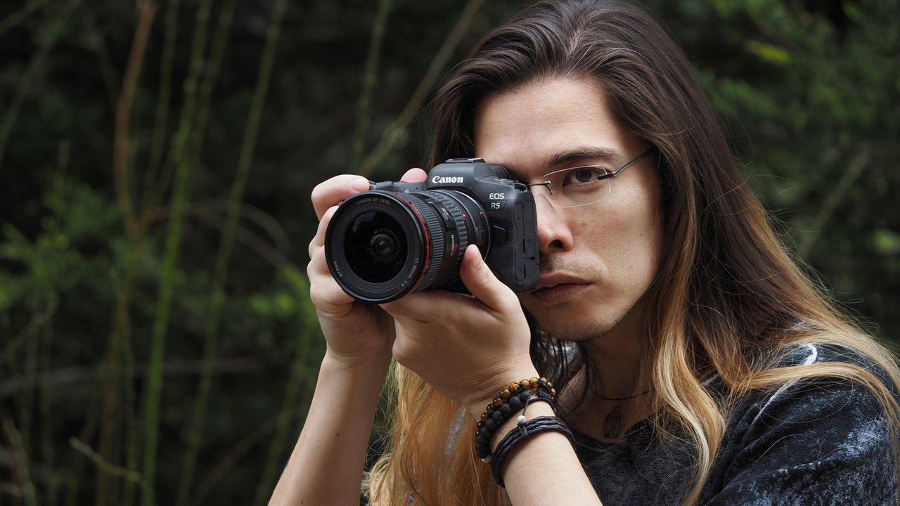 Man holding the Canon EOS R5 outside