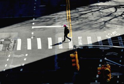 A person crosses the street on March 27, 2020 in New York City
