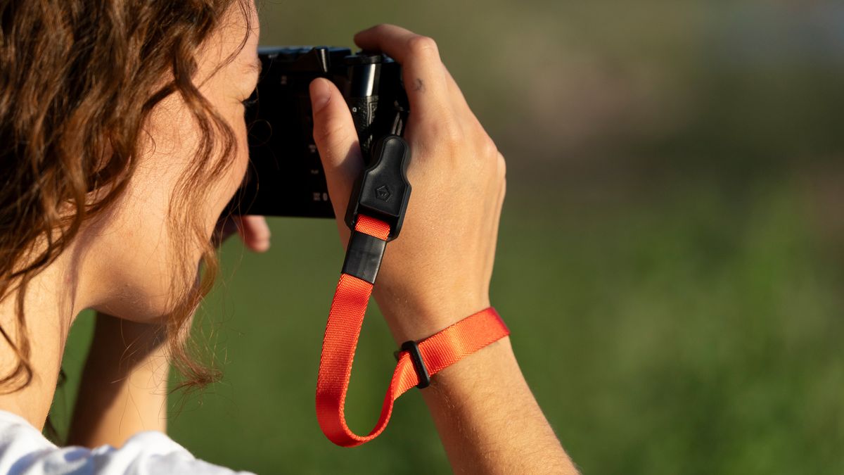 The Wandrd Magnetic Camera strap being used by a photographer