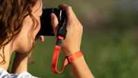 The Wandrd Magnetic Camera strap being used by a photographer