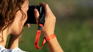 The Wandrd Magnetic Camera strap being used by a photographer