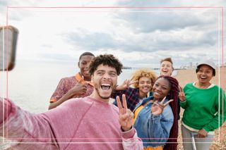 A group of happy teenagers taking a selfie on the beach