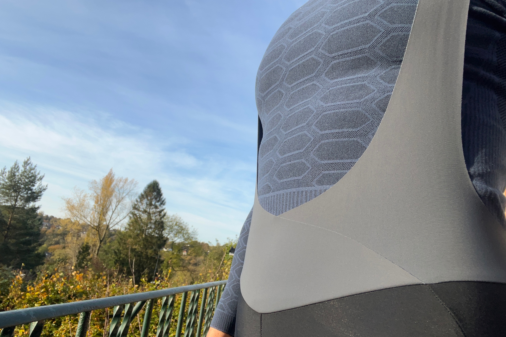 A close up of the front of the Q36.5 Light bib tights with blue sky and the tops of trees to the left