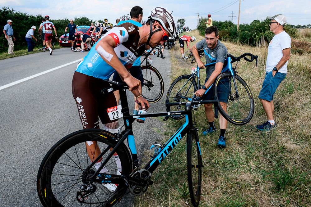 Silvan Dillier picks up his bicycle after being caught in a massive pack fall in the last kilometers of the fourth stage of the 105th edition of the Tour de France