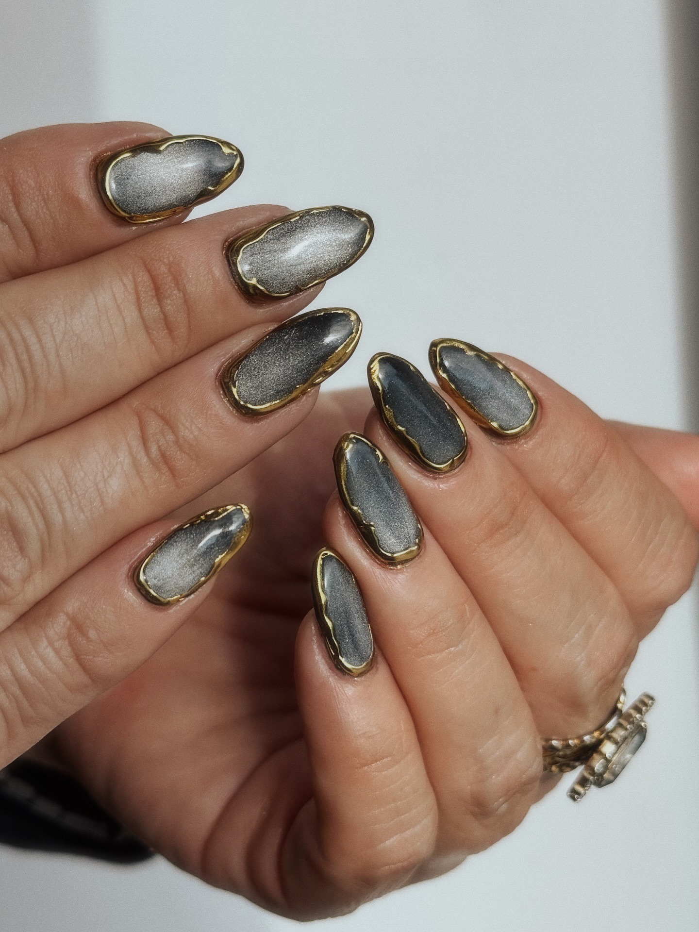 A silver manicure with gold detailing