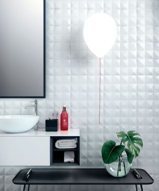 An example of bathroom lighting ideas showing a balloon-style wall light next to a sink
