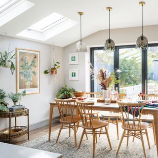 dining area with wooden table and chairs, pendant lights and hanging plants