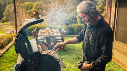 man cooking on a Traeger Timberline 1300 wood pellet grill