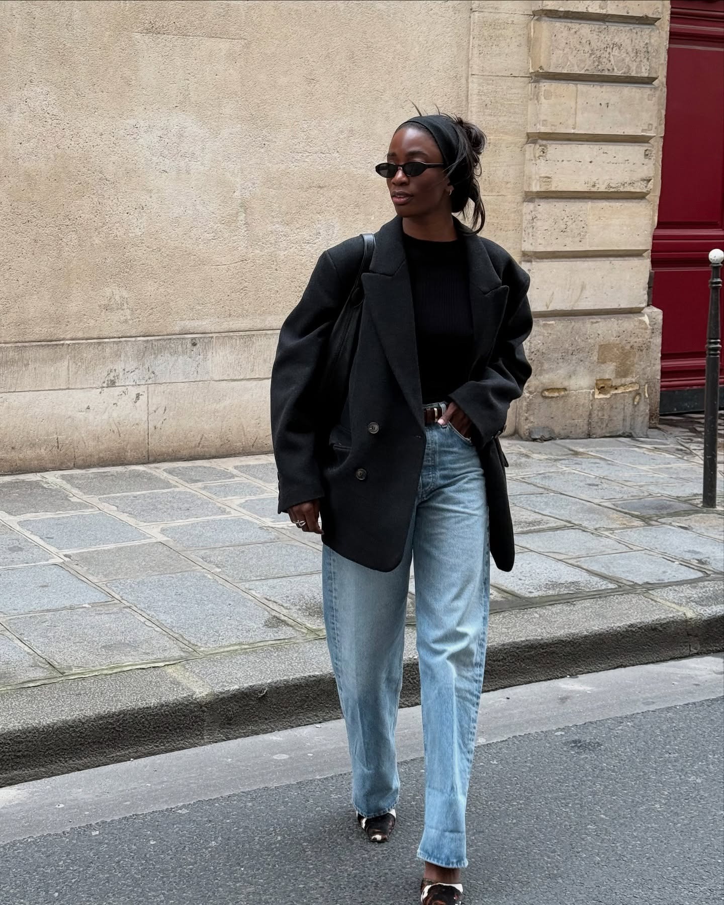 @_livmadeline wears blue jeans, black top, an oversized blazer, and joins the calf-hair shoe trend with a pair of cow-print heels.