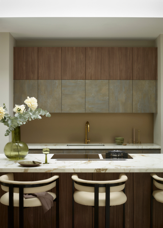 modern and chic kitchen with double height cabinets, half wood, half bronze. Marble countertop island with integrated hob.