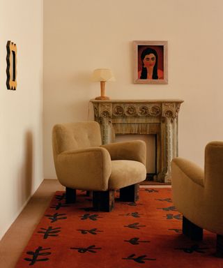 neutral living room with a large red rug and marble fireplace