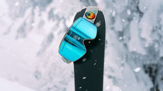 ski goggles balanced on single ski
