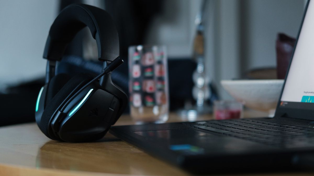 A Corsair Void Wireless V2 gaming headset on a desk and connected to a gaming laptop.