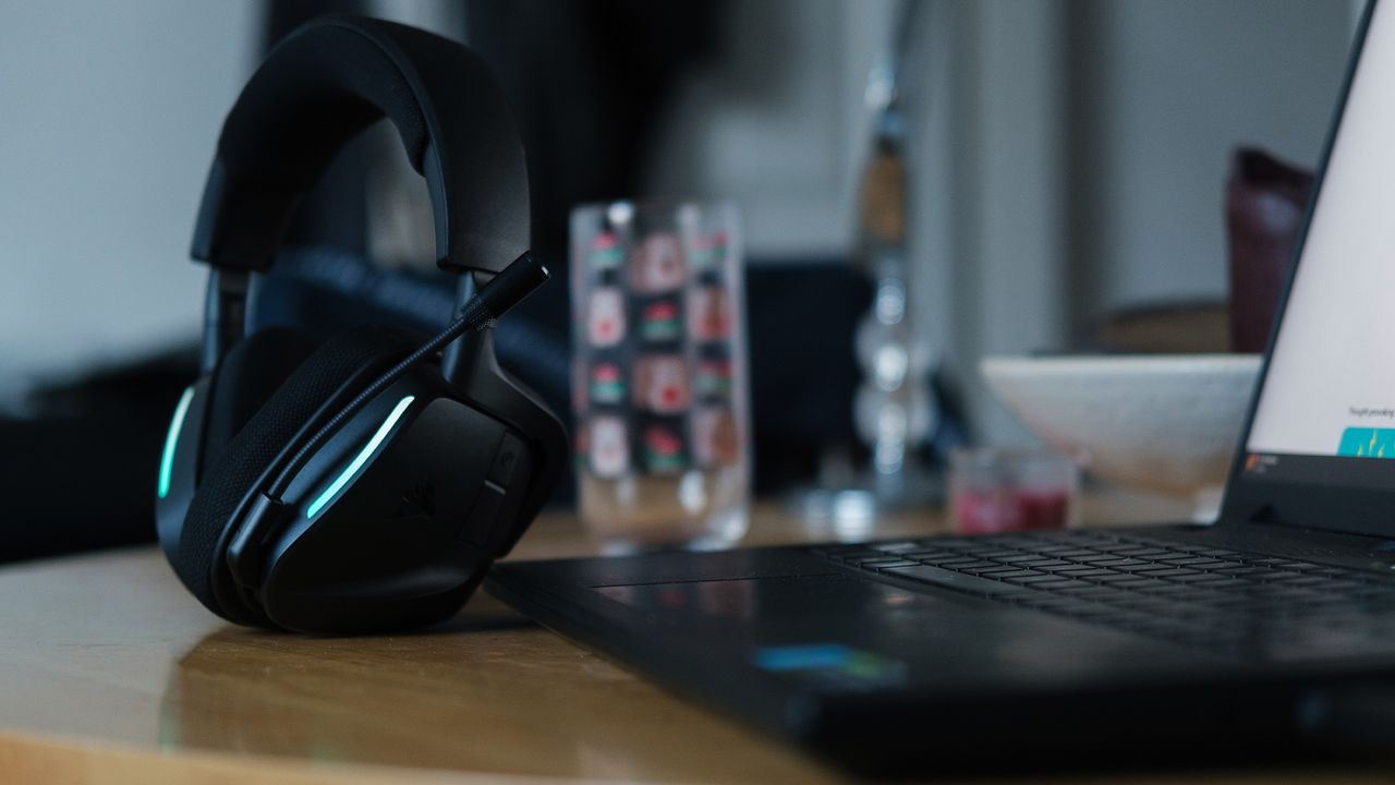 A Corsair Void Wireless V2 gaming headset on a desk and connected to a gaming laptop.