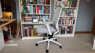 A profile shot of the Ergonomic Chair Pro in front of a bookshelf.