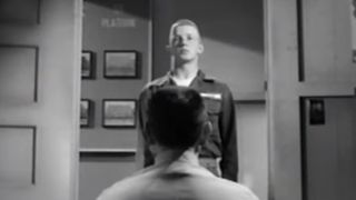 A man with his back to the camera inspects a military recruit in The D.I.