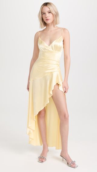 model wears butter yellow satin dress and heels