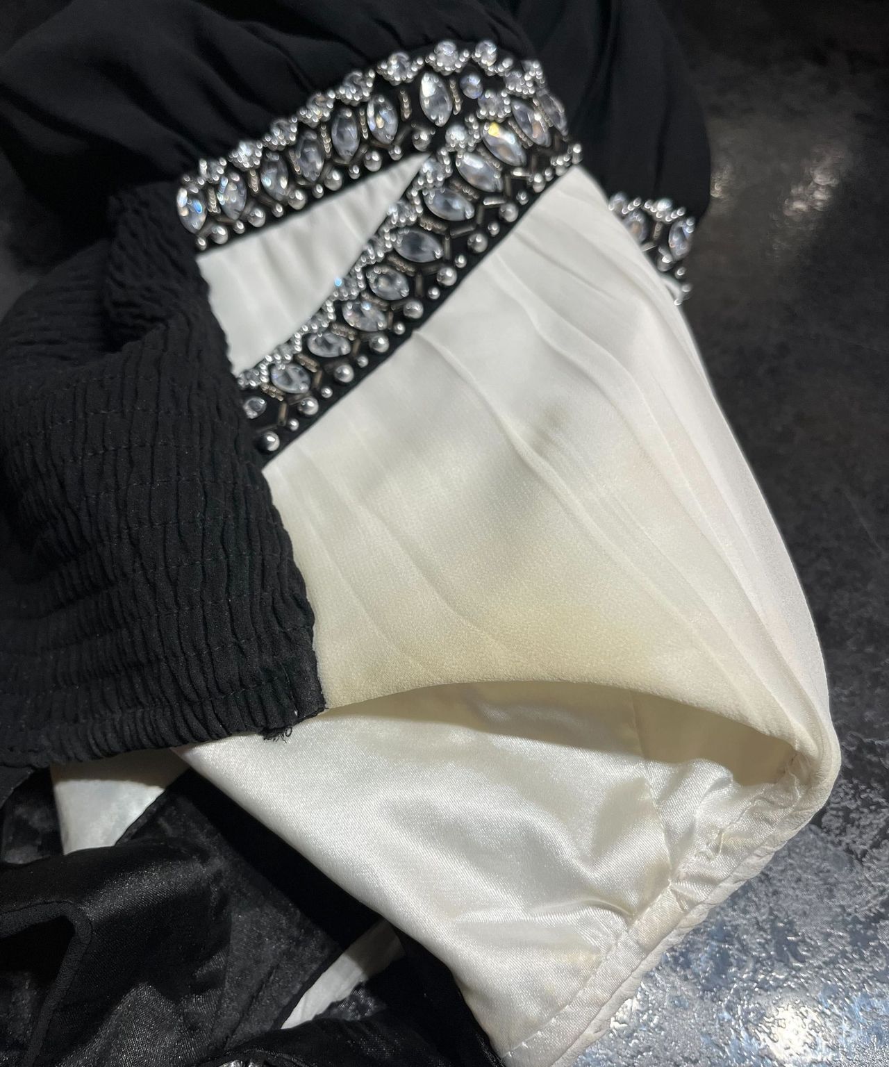 A cream and black dress with a yellowing stain in the armpit