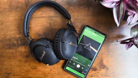 Spotify Lossless on phone next to Marshall headphones