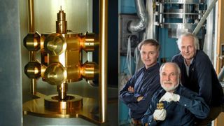 Left: A close-up image shows a torsion balance used to precisely measure the pull of gravity. Right: The Eöt-Wash Group poses with a torsion balance. From right to left they are Jens Gundlach, Eric Adelberger and Blayne Heckel.