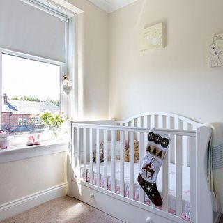 childrens bedroom with white wall and toddler bed and white window