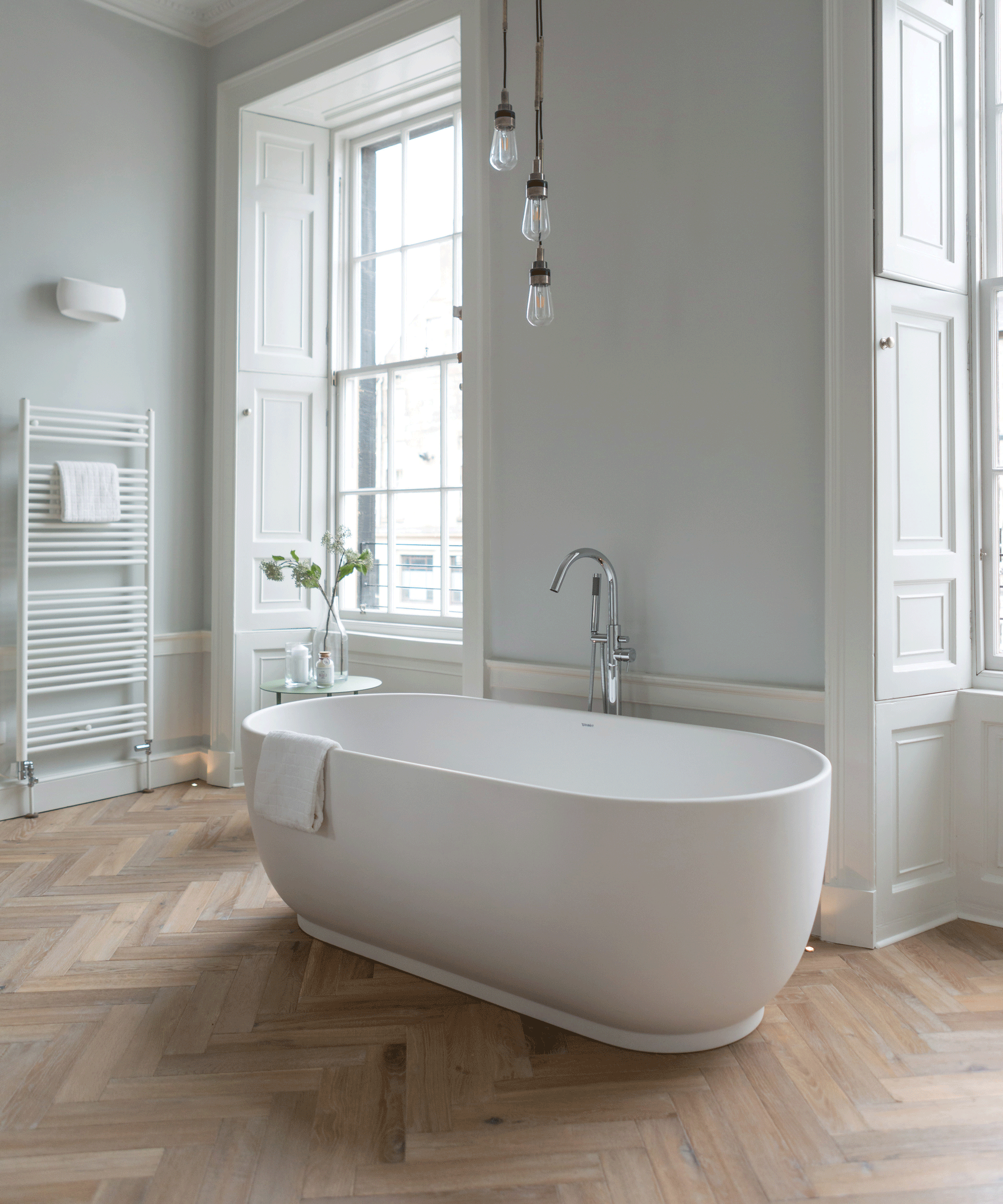 Freestanding bath in bathroom with engineered wood flooring